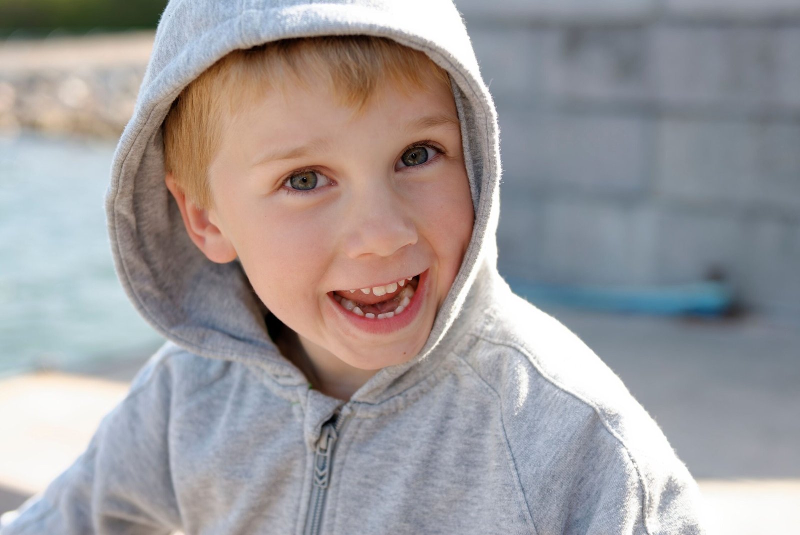 pexels photo 11363937 11363937 A smiling young boy enjoying a sunny day outdoors in his grey hoodie.