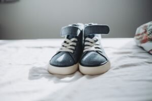 Close-up of trendy denim sneakers on a bed, perfect for fashion enthusiasts.