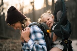 Mother and daughter enjoying an outdoor hike in the woods during autumn, showcasing happiness and bonding.